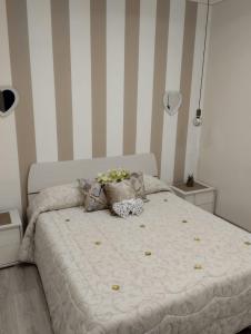 ein Bett in einem Schlafzimmer mit gestreiften Wänden in der Unterkunft Solemar Milicia in Altavilla Milicia