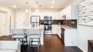 een keuken met witte kasten en een tafel en stoelen bij Landing Modern Apartment with Amazing Amenities (ID7549X82) in Orlando