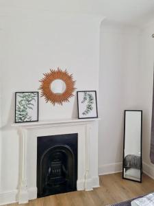 a living room with a fireplace and a mirror at Gravesend 2 bedroom Apartment, 2 mins walk to Station in Kent