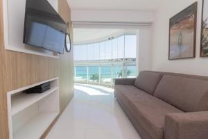 a living room with a couch and a flat screen tv at Flat Ocean View III in Rio de Janeiro
