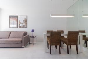 a living room with a couch and a table and chairs at Flat Ocean View III in Rio de Janeiro