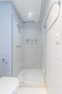 y baño con ducha de cristal y aseo. en Flat Ocean View III, en Río de Janeiro