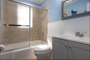 a bathroom with a toilet and a sink and a shower at Island Time- beautifully renovated bay view home in Seaside Heights