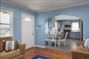 a kitchen and dining room with blue walls and a table at Island Time- beautifully renovated bay view home in Seaside Heights