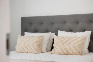 a bed with white pillows and a gray headboard at Modern Scandinavian Home in Stockholm in Stockholm