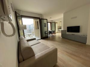 a living room with a couch and a television at Hospitami Apartment - 15 min Duomo Milano in Milan