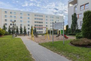 un parque infantil frente a un gran edificio en Duńska Chic Apartment, en Szczecin