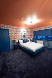 a bedroom with a large bed and an orange wall at Kip 23 JJs Emsworth in Emsworth