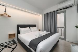 Schlafzimmer mit einem großen weißen Bett und einem Fenster in der Unterkunft Hotel Adonis Athens in Athen