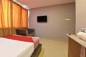 a hotel room with a bed and a chair at Hotel Rim Global Subang in Subang Jaya