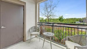 a balcony with two chairs and a table and a window at Landing Modern Apartment with Amazing Amenities (ID4250X31) in Frisco
