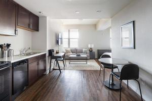 Landing Modern Apartment with Amazing Amenities (ID4229X79) في سان انطونيو: مطبخ وغرفة معيشة مع طاولة وكراسي