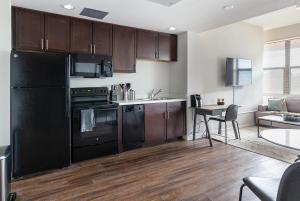 uma cozinha com electrodomésticos pretos e uma mesa num quarto em Landing Modern Apartment with Amazing Amenities (ID4229X79) em San Antonio