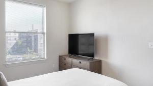 Landing Modern Apartment with Amazing Amenities (ID7274X30) في باتون روج: غرفة نوم مع تلفزيون في خزانة مع نافذة