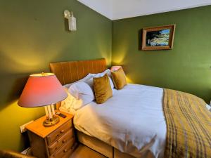 ein Schlafzimmer mit einem Bett mit einer Lampe auf einem Nachttisch in der Unterkunft Archway House in Grantham