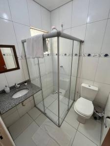 a white bathroom with a toilet and a sink at Apartamento em Petrolina in Petrolina