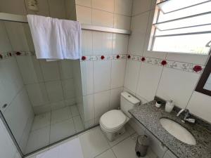 a bathroom with a toilet and a sink and a window at Apartamento em Petrolina in Petrolina