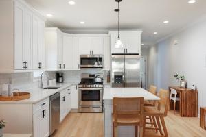 a kitchen with white cabinets and a table with chairs at The Pelican's Perch: New Build in Seaside Heights