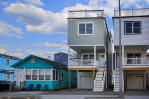 a house with two balconies next to a row of houses at The Pelican's Perch: New Build in Seaside Heights
