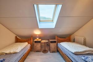 a attic room with two beds and a window at Le koala in Villard-de-Lans