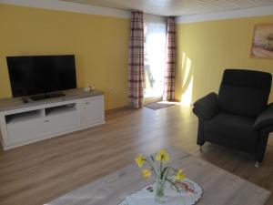 a living room with a television and a couch and a table at Fischerhäusle in Oberried