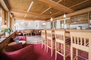 a restaurant with a bar and tables and chairs at Hotel Bradabella - Montafon in Gargellen