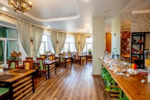 a restaurant with wooden floors and tables and chairs at Отель Ямской in Voronezh