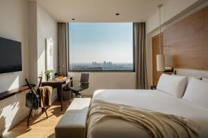 ein Hotelzimmer mit einem Bett, einem Schreibtisch und einem Fenster in der Unterkunft Torre Melina, a Gran Meliá Hotel in Barcelona