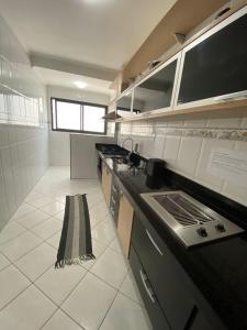 eine Küche mit Herd und Arbeitsplatte in der Unterkunft Apto Moderno com Churrasqueira Gourmet, apenas 150m da Praia in Praia Grande