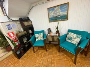 two blue chairs and a table in a room at BahiaCaracoles Apart in Antofagasta