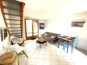 sala de estar con sofá y mesa en Maisonnette 4 personnes avec piscine commune à 500 mètres de la plage - MAEL, en Guidel