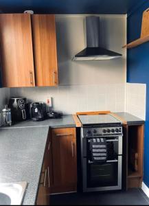 a kitchen with a stove and a counter top at Entire 2 bedroom house in Hackney in London