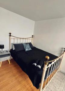 um quarto com uma cama com um edredão preto em Entire 2 bedroom house in Hackney em Londres