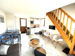 sala de estar con escalera, mesa y sillas en Maisonnette 4 personnes avec piscine commune à 500 mètres de la plage - MAEL, en Guidel