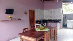 eine Küche mit einem Holztisch mit einer Obstschale darauf in der Unterkunft Casa Porto in Porto Seguro