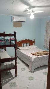 ein Schlafzimmer mit zwei Betten und einem Deckenventilator in der Unterkunft Casa Porto in Porto Seguro