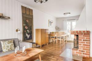 ein Wohnzimmer mit einem Sofa und einem Kamin in der Unterkunft Retro Retreat with Modern Comforts in Stockholm