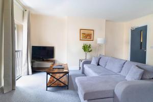 a living room with a couch and a tv at The Windmill Hotel in Lincolnshire