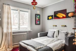 Schlafzimmer mit einem Bett und einem Fenster in der Unterkunft Retro Retreat with Modern Comforts in Stockholm