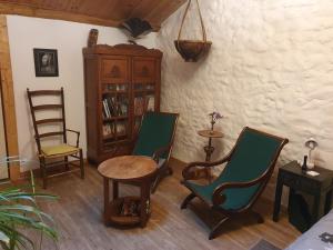 a room with chairs and a table and a book shelf at Chambre d’hôtes de Vauguenige in Saint-Pardoux +10 photos