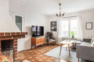 a living room with a couch and a fireplace at Retro Retreat with Modern Comforts in Stockholm