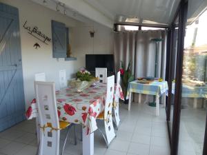 ein Esszimmer mit einem Tisch und Stühlen in einem Zimmer in der Unterkunft St Cyprien Maison de vacances climatisée avec jardin in Saint-Cyprien