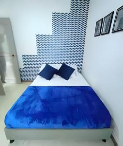 a bedroom with a blue and white bed with pillows at GURUS FR | Apartamento Central Cerca al estadio y aeropuerto in Pereira