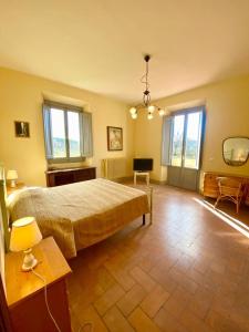 a large bedroom with a bed and a desk and windows at Fattoria Casabianca in Bucine