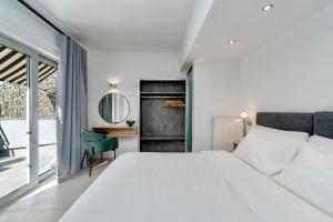 Schlafzimmer mit einem großen weißen Bett und einem Schreibtisch in der Unterkunft Hotel Adonis Athens in Athen