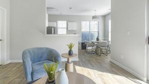 un salon avec une chaise bleue et une table dans l'établissement Landing Modern Apartment with Amazing Amenities (ID9752X95), à Durham