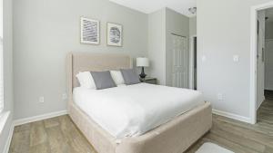 - une chambre blanche avec un grand lit blanc et des oreillers dans l'établissement Landing Modern Apartment with Amazing Amenities (ID9752X95), à Durham