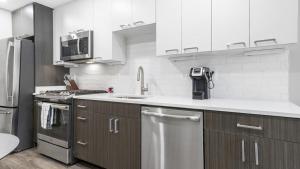 a kitchen with stainless steel appliances and white cabinets at Landing Modern Apartment with Amazing Amenities (ID8363X48) in Arlington