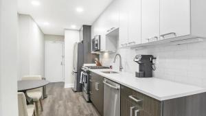 a kitchen with white appliances and a table in it at Landing Modern Apartment with Amazing Amenities (ID8363X48) in Arlington