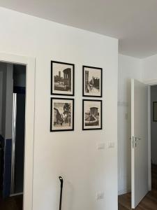 vier ingelijste foto's op een witte muur in een kamer bij Suite Monolocale Roma Eur in Rome